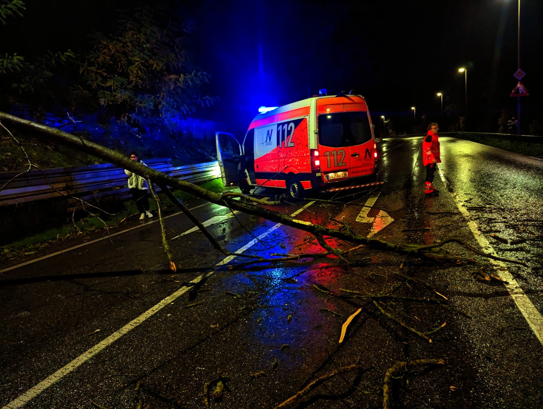 Aviccena Rettungsdienstfahrzeug bei nächtlichem Einsatz mit Blaulicht auf nasser Fahrbahn